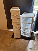 Two plastic storage units standing side by side, one with wicker look front, one Rubbermaid with clear drawers.