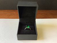 Ring displayed inside a black branded box with velvety interior.