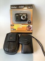 Full view of Vivitar camera in original packaging with two camera cases in front.