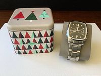 Watch and holiday-themed Fossil tin box on table