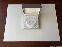 Freshwater pearl stud earrings displayed in original box on white background.