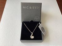 Nic & Syd branded box with Swarovski crystal necklace inside, showing pendant and chain neatly displayed.
