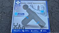Front of the box showing the massager image and features such as ergonomic rubber finish, dual grips, and four speed levels.