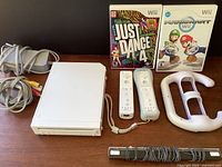 Overview of all items laid out: console, cables, controllers, wheel, games and sensor bar