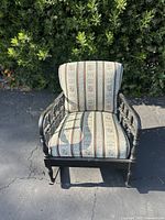 Front view of the black wooden rocking chair with striped floral upholstery.