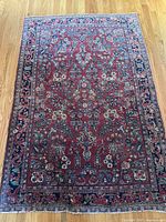 Full‐view of rug laid flat on oak floor, showing overall pattern and border