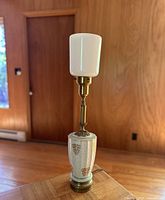 Full view of antique table lamp showing porcelain base, brass fittings, and white glass shade