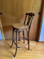 Full view of the bentwood tall cafe chair showing the chair structure, seat, and legs.