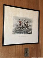 Framed art print showing rider on white horse with mat and black frame, mounted on wood wall.