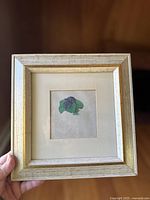 Front view of framed vintage Durer 'Bunch Of Violets' art, showing violet flowers and leaves on cream matte under glass in beige and gold wooden frame.