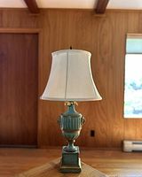 Full front view of the entire lamp showing its shape, color, and fabric shade.