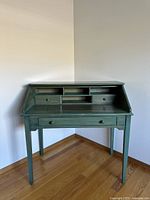 Front angle view of the vintage rustic wood desk with slanted lid, drawers and shelving.