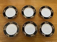 Overhead view of six identical plates arranged in two rows of three on a wood surface
