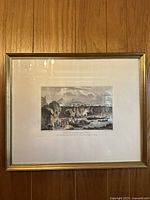 Full view of one framed etching print depicting a coastal scene with cliffs, boats, and people, and Mount Vesuvius in the background.