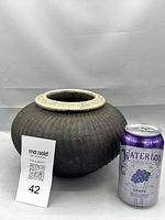 Side view of the vintage Raku pottery vase next to a soda can for scale, showing the ribbed dark textured body and crackle-glazed rim.