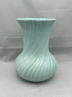 Full view front of the aqua green swirl vase on a plain background.