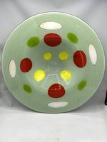 Top-down photo of the bowl showing pale green base with red, yellow, green, and white geometric inclusions.