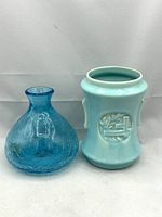 Front view photo focusing on the turquoise Pacific Pottery vase with embossed laurel motif showing shape and glaze finish.