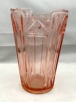 Front view of pink Art Deco glass vase showing faceted vertical flutes and scalloped rim