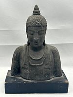 Front view of the Buddha bust mounted on black rectangular base, showing size and general condition.