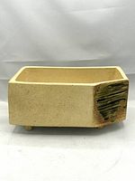 Front view of the rectangular beige stoneware Ikebana planter with an olive green textured glaze accent on one end.