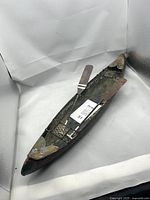 Photo of the metal toy canoe from an angled top view showing the left side and the metal paddle attached inside.