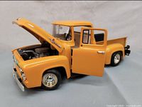 Side view of the yellow 1956 Ford F-100 model with open hood and driver door showing engine and interior detail.