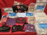 Photo showing multiple Avon new makeup bags, pouches, and purses of various colors and styles, some packaged, some loose.