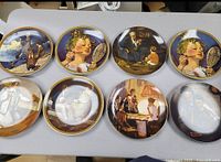 Top view of eight collectible plates showing the front side with various Norman Rockwell artwork.