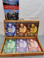 Contents of the open box showing 6 color-coded DVD cases and a book titled 'The Oxford of Inspector Morse'.