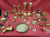 Full table showing all brass items arranged on red cloth.