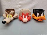 Front view of the three ceramic Looney Tunes character mugs: Wile E. Coyote, Yosemite Sam, and Daffy Duck.