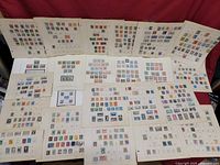 Wide view of multiple album pages laid out with many vintage stamps affixed in rows.