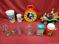 Photo showing entire lot including clock, toy truck, dominoes, cups, glasses, and thermos