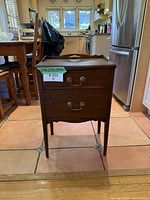 Front view of the solid wood accent table showing two drawers and brass handles.