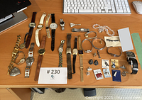 Overview of watches, necklaces, bracelets, earrings, rings and charms arranged on desk