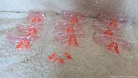 10 pairs of safety glasses individually packaged in clear plastic bags, arranged in clusters.