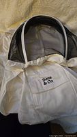Photo of 4XL Bees & Co beekeeping suit showing white fabric and black mesh veil around the head area with Bees & Co branded chest pocket.