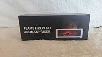 Front view of the retail box showing product name Flame Fireplace Aroma Diffuser with an image of the product.