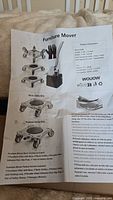 Photograph of instruction paper showing diagrams and parts list for the furniture mover set.