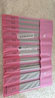 Set of silver knitting needles in pink roll-up case labeled with sizes from 2.0 mm to 8.0 mm.