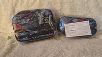 Floral-patterned lockable lunch bag and pencil case in original sealed packaging displaying front side with tags.