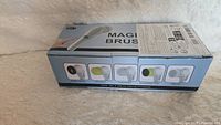 Box showing Magic Brush branding with images of the interchangeable heads on the side of the box.