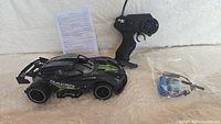 Full lot showing remote control car, pistol grip controller, battery pack with connectors, and instruction sheet.