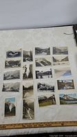 Overview photo showing all 20 postcards laid out, mix of black and white and color-tinted images featuring Canadian Rocky Mountain landscapes.