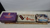 Photo showing the three board games arranged side-by-side: Balderdash, Keyword Crossword Word Game, and Probe Game