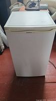 Front view of white Goldstar mini fridge with closed door.