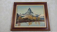 Framed oil painting showing mountain landscape with reflection and autumn trees