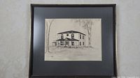 Full view of the framed black and white sketch showing the entire house and trees in the background.