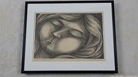 Framed and matted lithograph showing the full artwork of a resting woman with eyes closed, rendered in black and white.